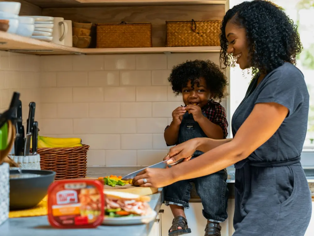 A mother and son laughing while cooking