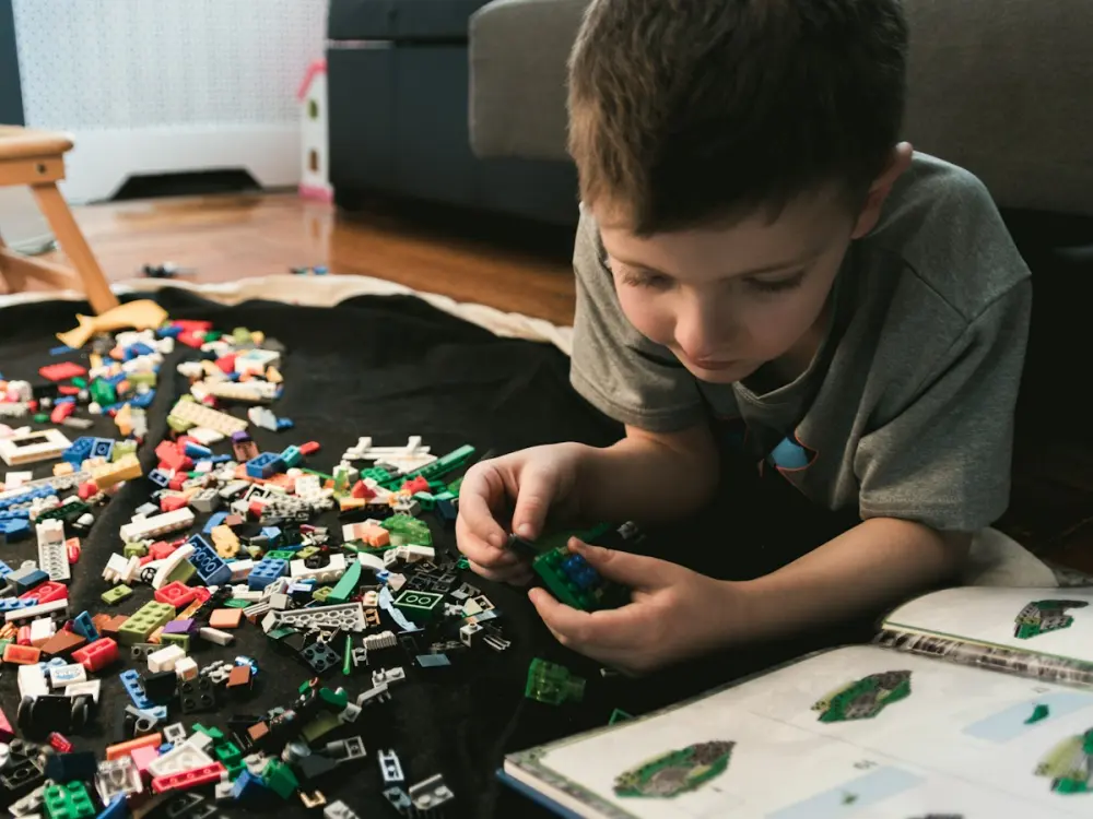 A boy building with Lego on the floor
